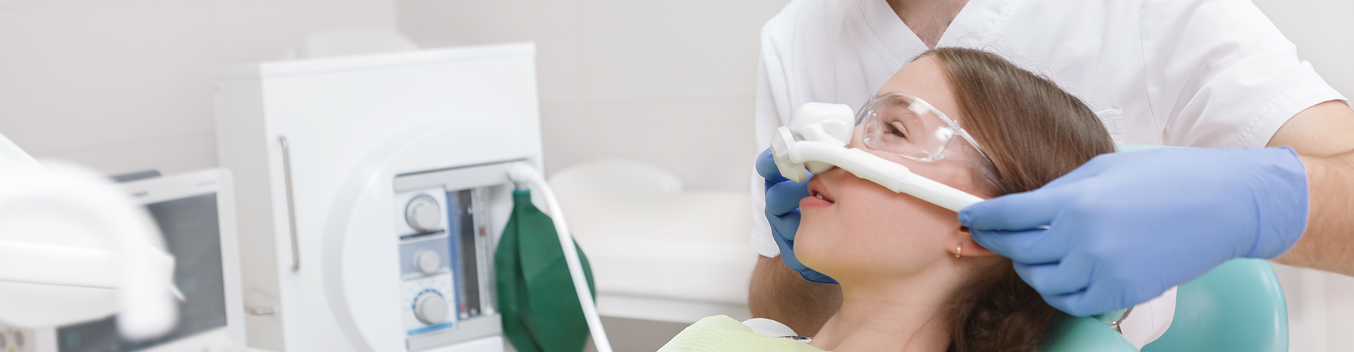 dentist placing breathing mask over woman's nose